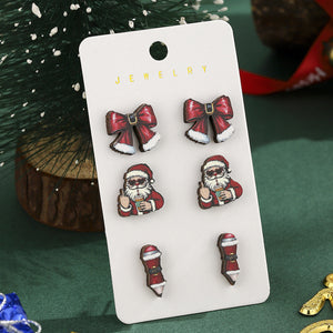 Christmas earring set card beside small snowy Christmas tree